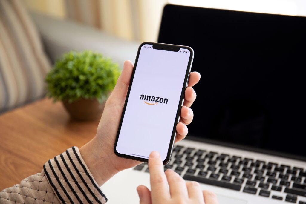 Frau hält iPhone X mit Internet-Shopping-Service Amazon

